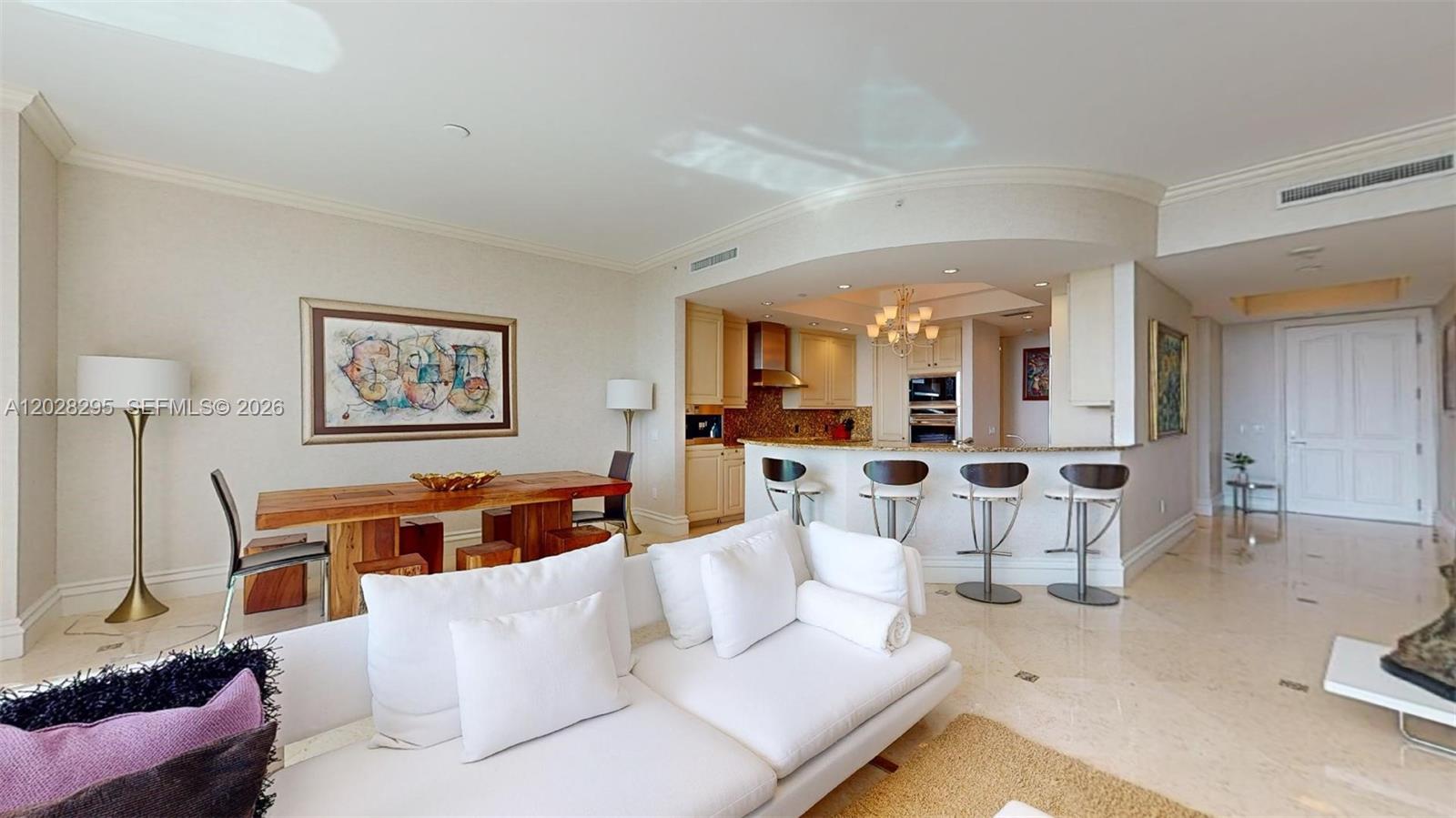 This open-concept living and dining area features a kitchen island with bar seating — 10295 Collins Ave # 205, Bal Harbour FL 33154, BAL HARBOUR, FL