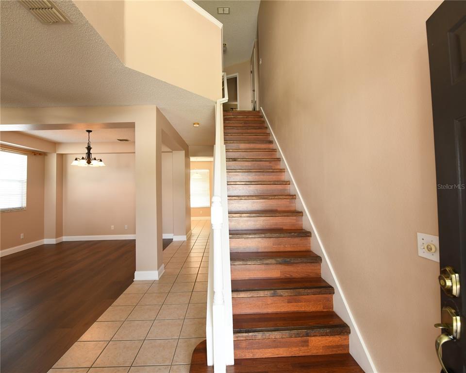 An entryway features a wooden staircase, tiled flooring, and an adjacent living area — 812 JADE FOREST AVENUE, ORLANDO, FL