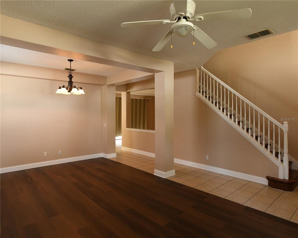 A living area with wood flooring, a staircase, a ceiling fan, and a dining chandelier — 812 JADE FOREST AVENUE, ORLANDO, FL