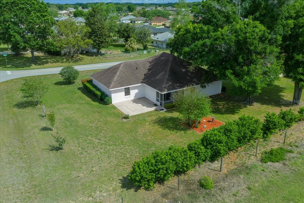 An aerial view shows a single-story house with a concrete patio and large trees — 3498 NW 50TH COURT, OCALA, FL