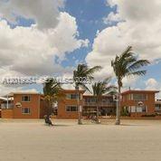 A multi-story orange building sits behind a sandy beach with several palm trees — 0 N Surf Rd, Hollywood FL 33019, HOLLYWOOD, FL
