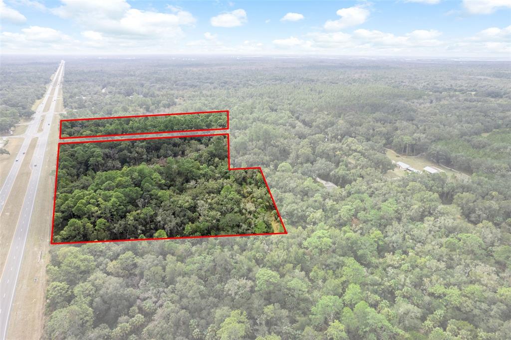 An aerial view shows two wooded parcels of land outlined in red near a highway — 11620 W GARNET COURT, CRYSTAL RIVER, FL