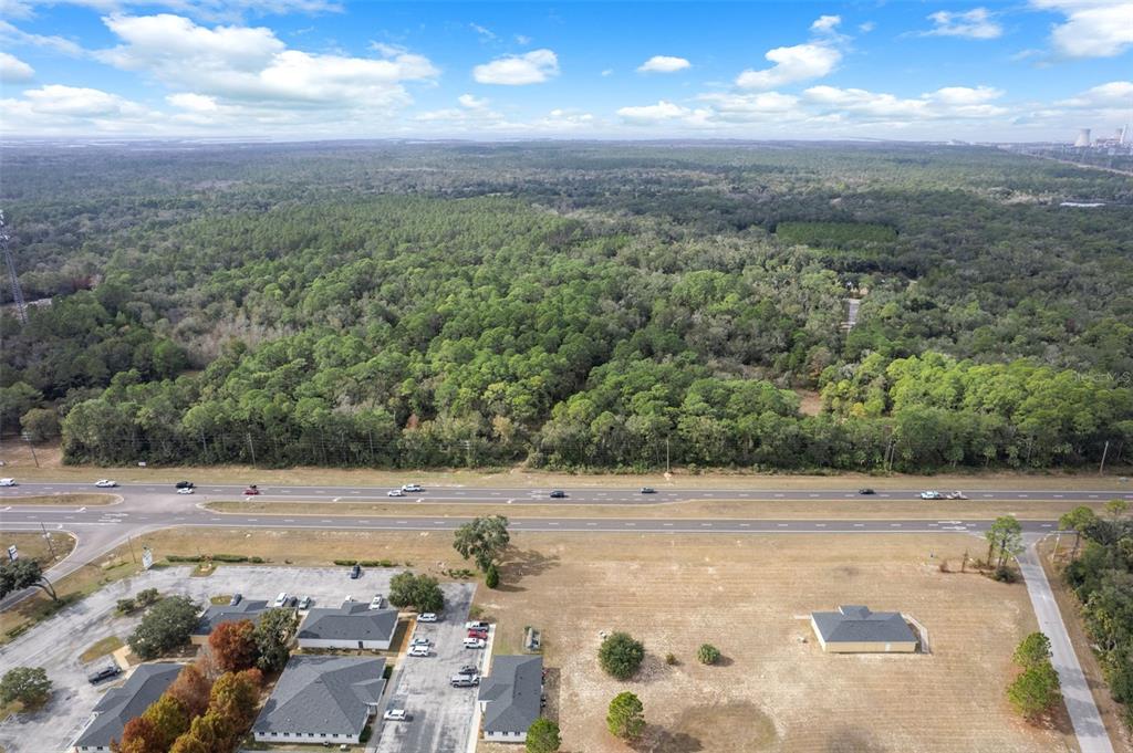 An aerial view shows a commercial property with parking lots adjacent to a multi-lane highway — 11620 W GARNET COURT, CRYSTAL RIVER, FL
