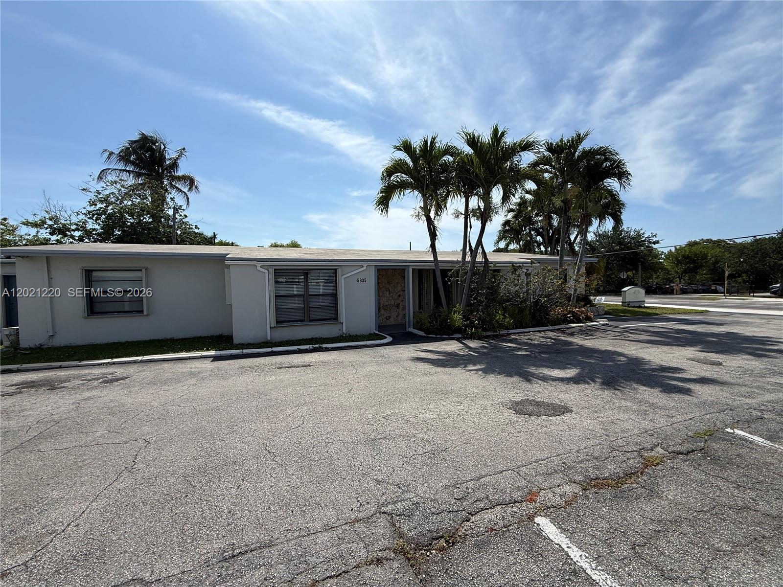 A single-story building with a flat roof and palm trees sits beside an asphalt parking lot — 5935 Taft St, Hollywood FL 33021, HOLLYWOOD, FL