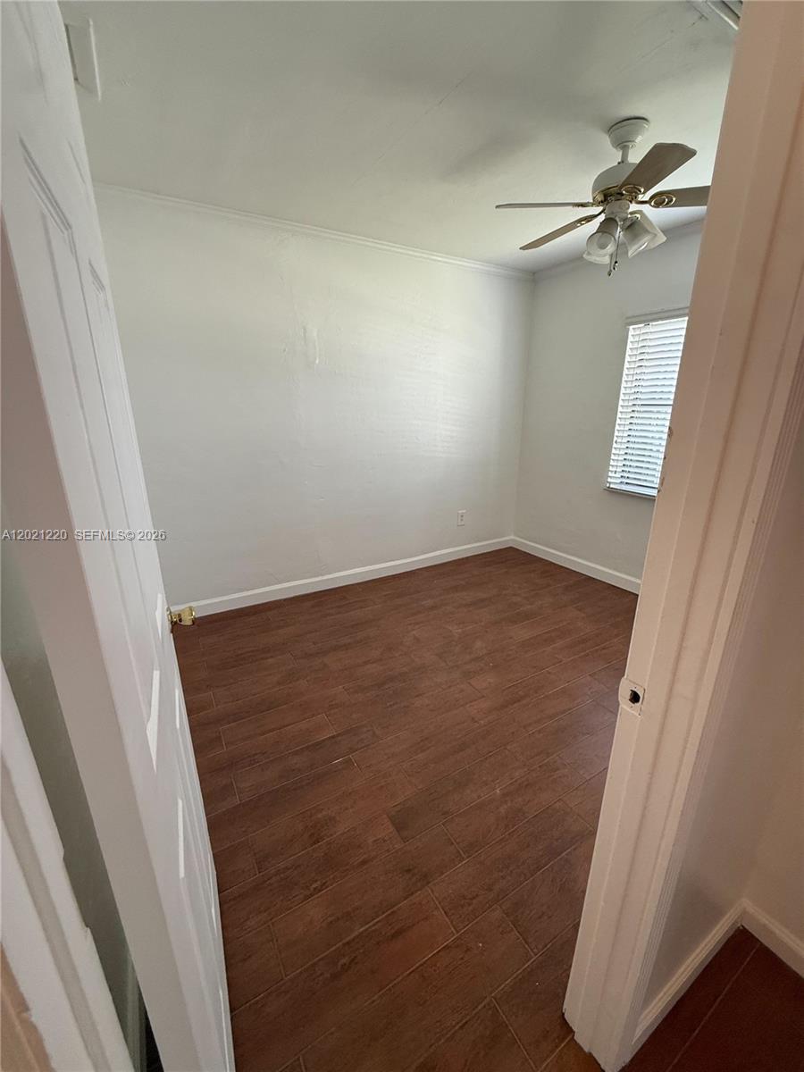 An empty bedroom features white walls, a ceiling fan, and wood-look tile flooring — 5935 Taft St, Hollywood FL 33021, HOLLYWOOD, FL