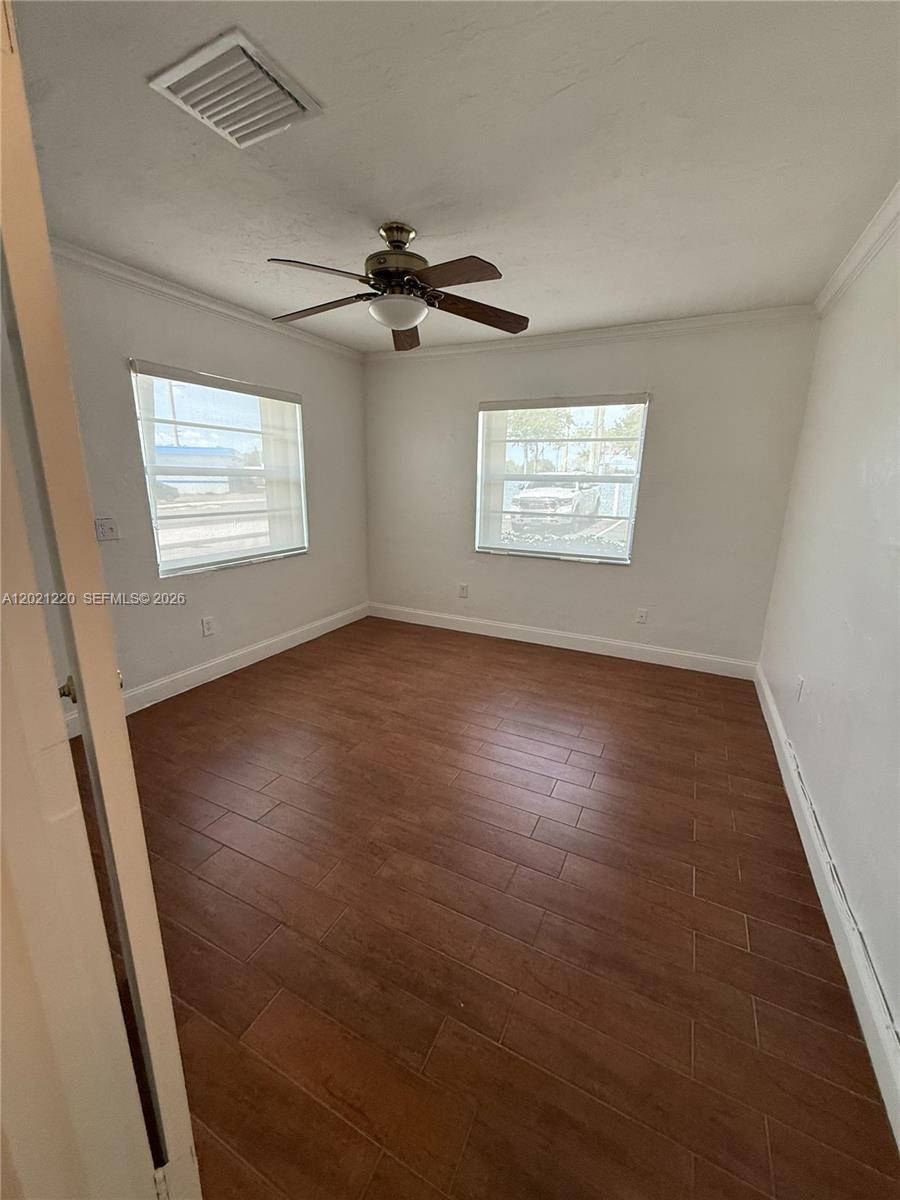 This bedroom features wood-look tile flooring, a ceiling fan, and two windows with blinds — 5935 Taft St, Hollywood FL 33021, HOLLYWOOD, FL