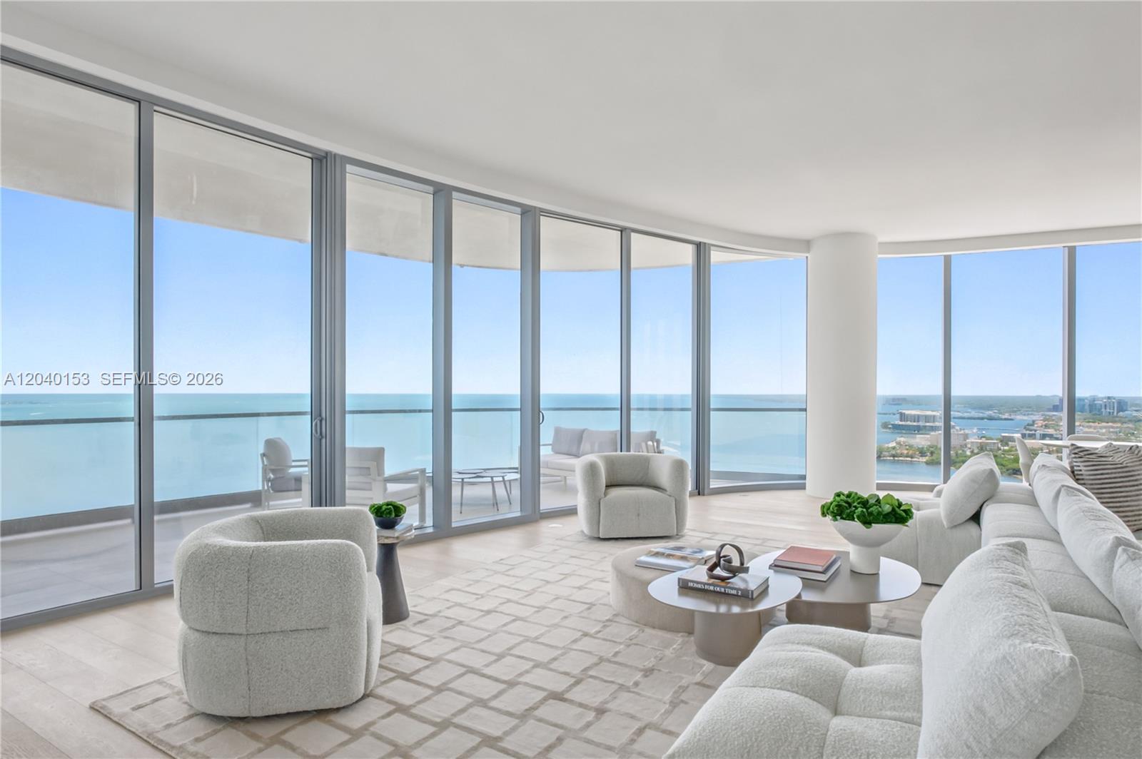 A modern living room features floor-to-ceiling windows with expansive ocean views and neutral furniture — 175 SE 25th., Miami FL 33129, MIAMI, FL