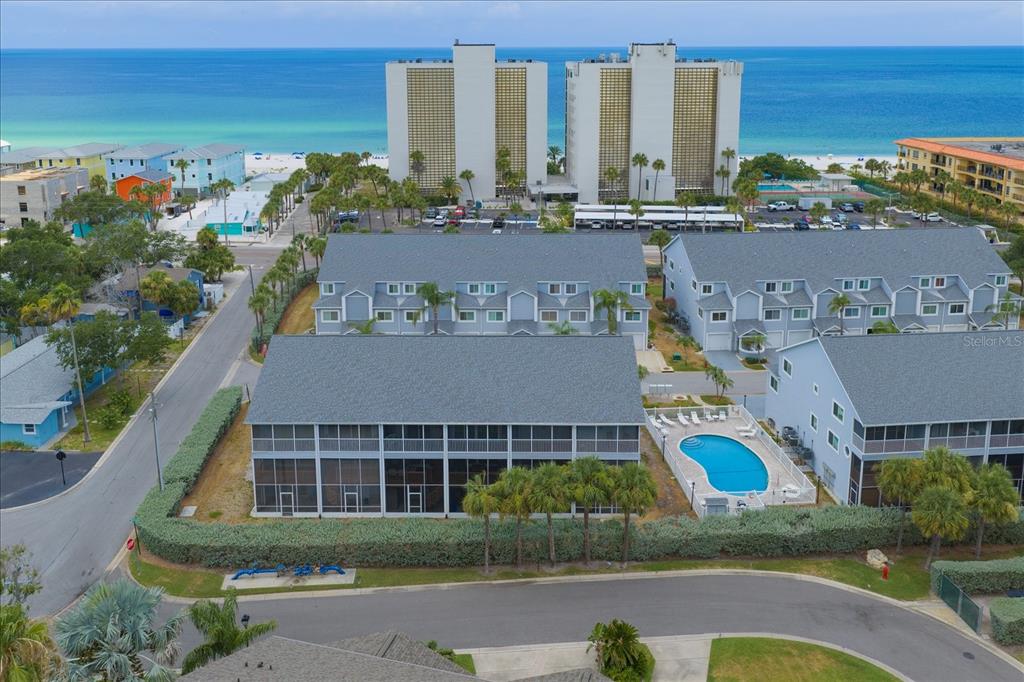 An aerial view shows a multi-story residential complex with a swimming pool near the beach — 901 HARBOUR HOUSE DRIVE, INDIAN ROCKS BEACH, FL