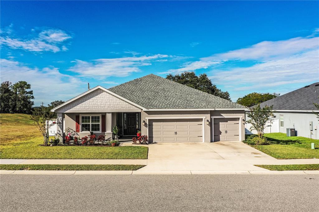 A single-story suburban house with a gray exterior, a two-car garage, and a front porch — 261 WALKERS POINT DRIVE, AUBURNDALE, FL