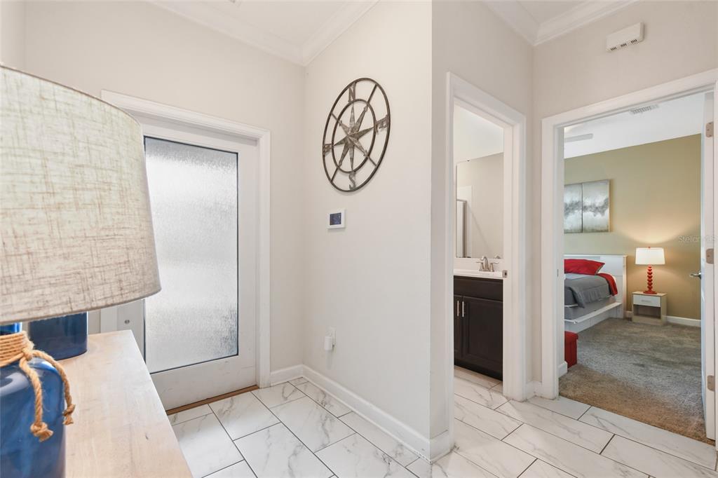A tiled entryway features a compass wall decoration, a glass-paneled door, and two doorways — 1244 CHALLENGE DRIVE, DAVENPORT, FL