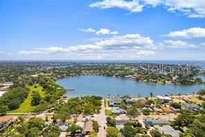 An aerial view shows a lake surrounded by residential homes and lush green trees — 144 30TH AVENUE N, ST PETERSBURG, FL