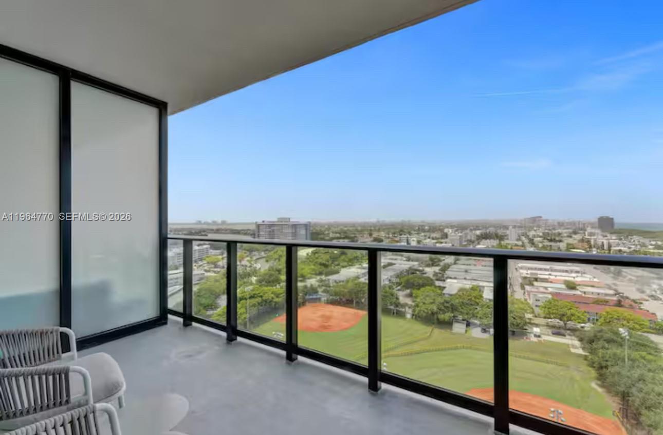 A high-rise balcony overlooks a baseball field and a city landscape under a clear sky — 580 72 # 1713, Miami Beach FL 33141, MIAMI BEACH, FL