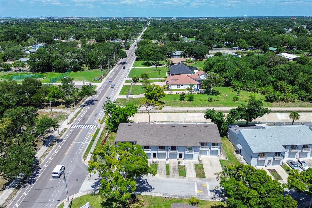 An aerial view shows a multi-unit townhouse building next to a road and green space — 6204 92ND PLACE N UNIT 3705, PINELLAS PARK, FL
