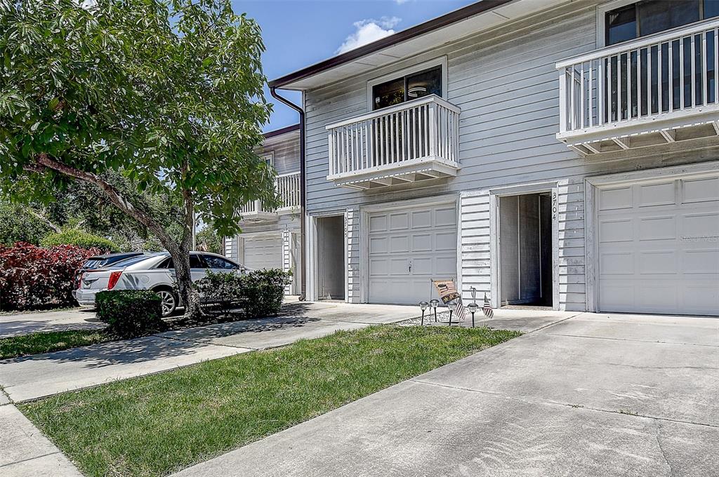 A kitchen and dining area with white cabinets, stainless steel appliances, and a wooden table — 6204 92ND PLACE N UNIT 3705, PINELLAS PARK, FL