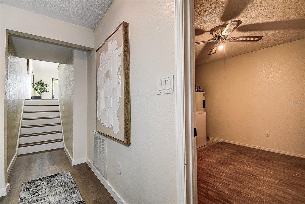 The exterior of a multi-unit residential building features white siding, balconies, and garage doors — 6204 92ND PLACE N UNIT 3705, PINELLAS PARK, FL