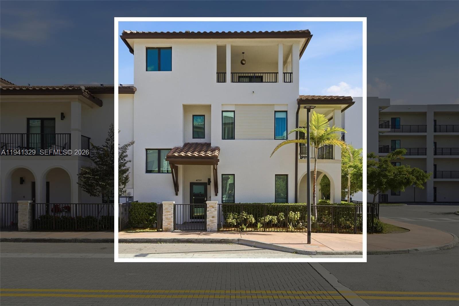 A three-story white stucco townhouse features a tiled entryway roof and a top-floor balcony — 4250 NW 83rd Ave, Doral FL 33166, DORAL, FL