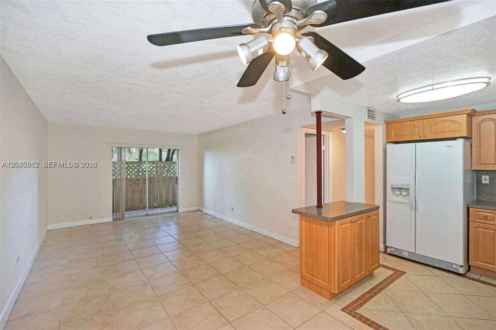 A kitchen and living area with tile floors, a ceiling fan, and a small island — 8500 SW 109 Ave # 102, Miami FL 33173, MIAMI, FL