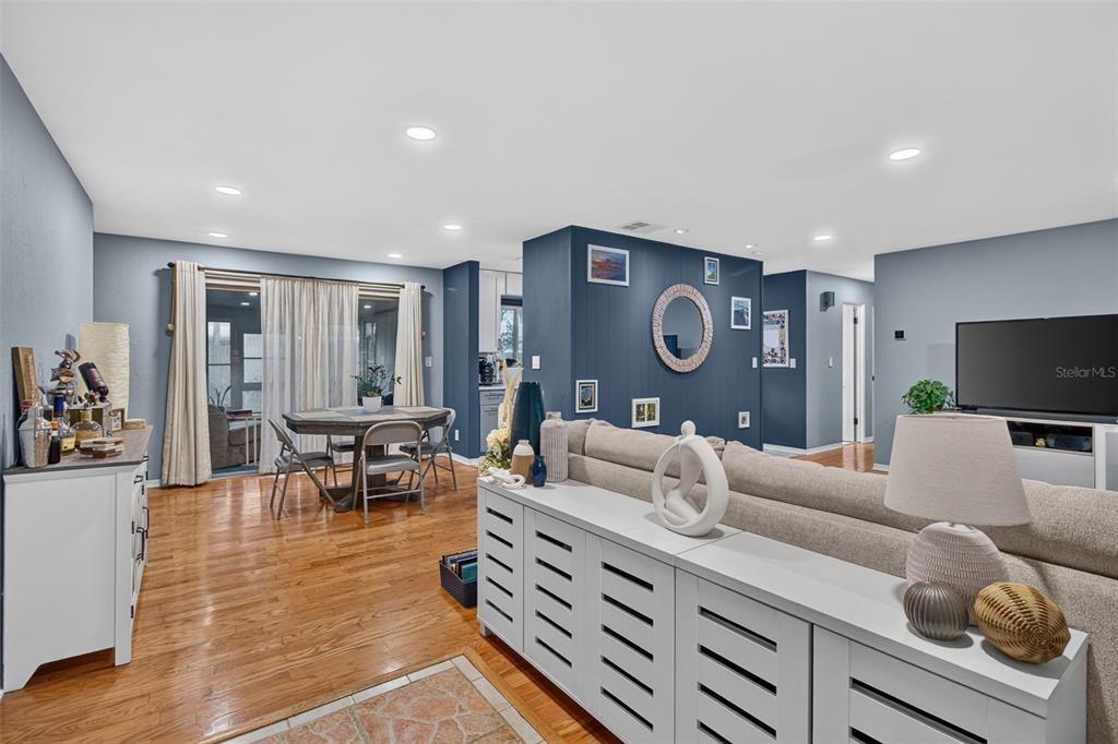 A living room and dining area with hardwood floors, a blue accent wall, and furniture — 11373 67TH AVENUE, SEMINOLE, FL