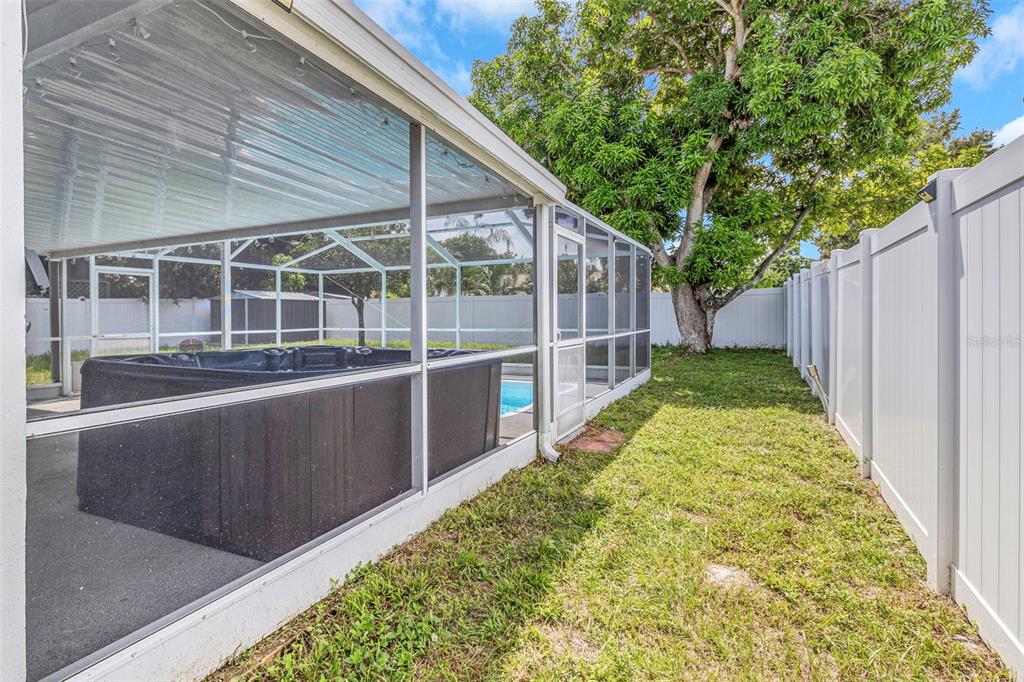 A screened-in patio area features a hot tub and a small pool in a backyard — 6842 62ND AVENUE N, PINELLAS PARK, FL