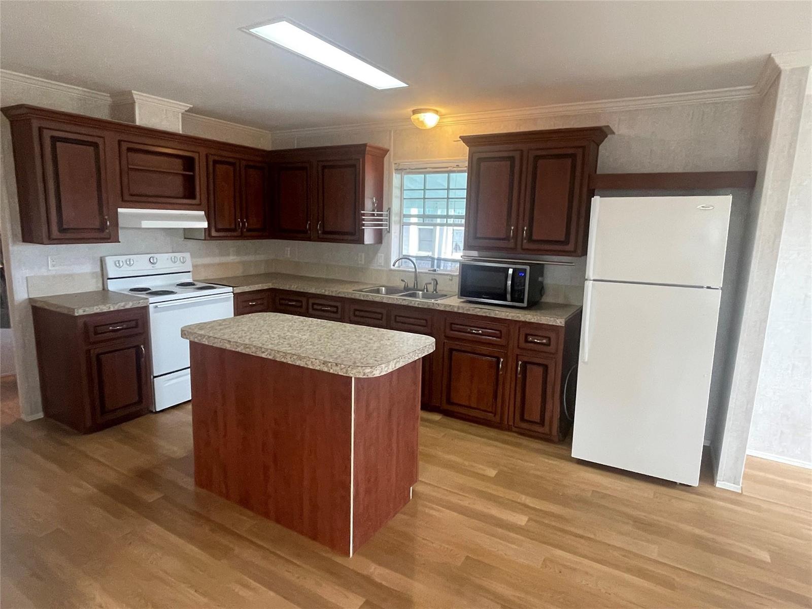 A kitchen features dark wood cabinets, a central island, laminate countertops, and white appliances — 2321 SW 85th Avenue, Davie FL 33324, DAVIE, FL