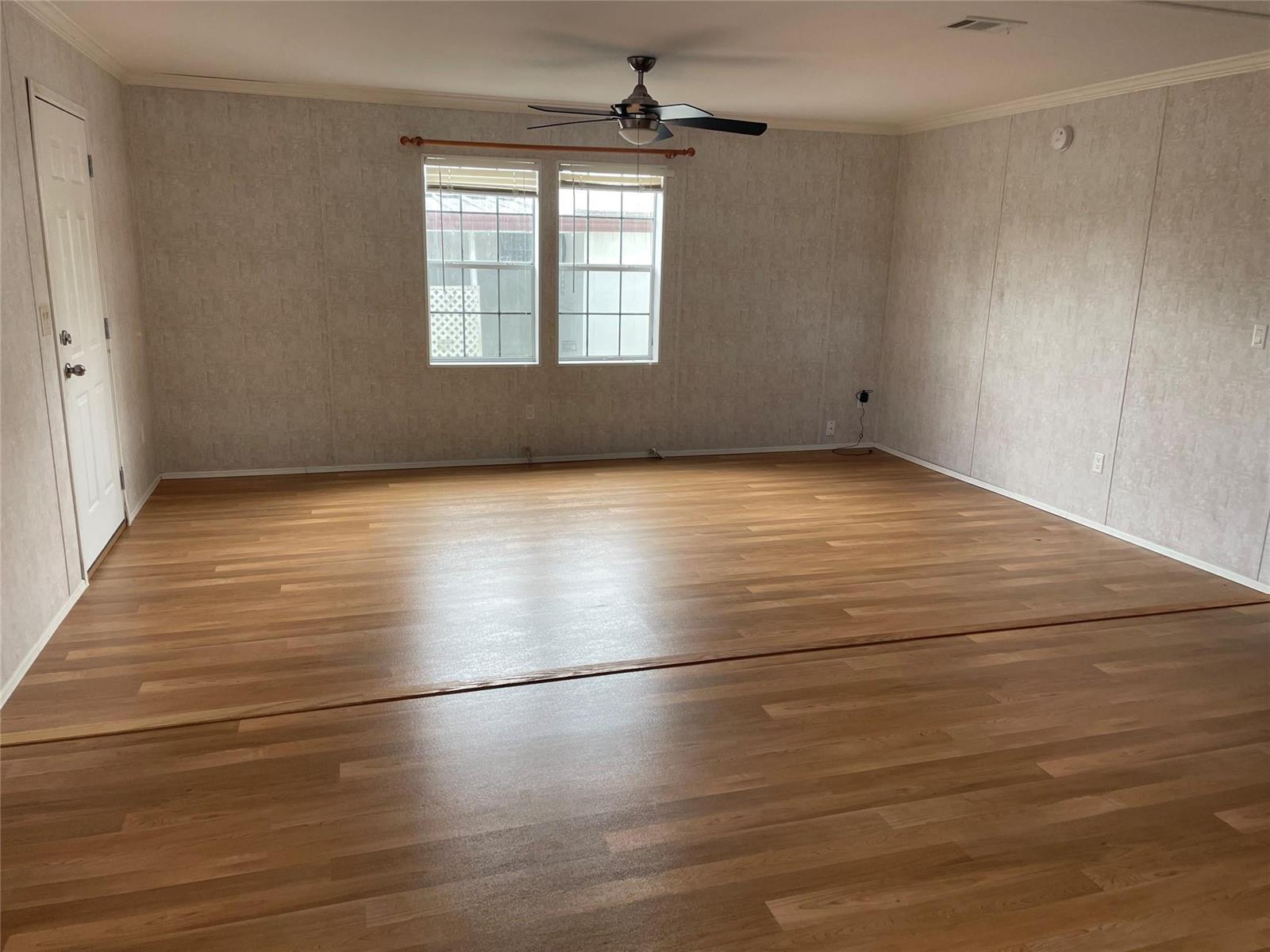 An empty room features light wood-look flooring, textured wallpaper, and a ceiling fan — 2321 SW 85th Avenue, Davie FL 33324, DAVIE, FL