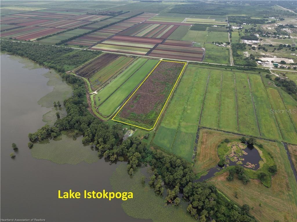 An aerial view shows a rectangular plot of land bordered by farmland and Lake Istokpoga — 76 WEEKS ROAD, LAKE PLACID, FL