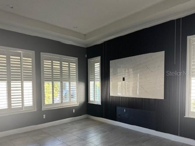 A living room features gray walls, white plantation shutters, and a black slatted accent wall — 12518 BOVET AVENUE, ORLANDO, FL