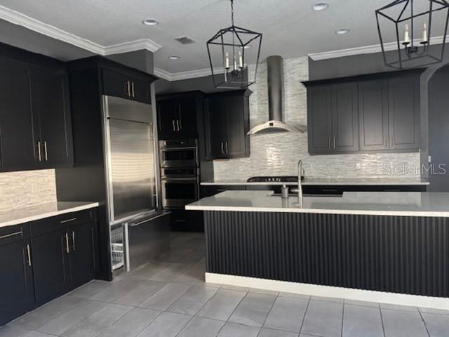 A modern kitchen features dark cabinetry, stainless steel appliances, and a large central island — 12518 BOVET AVENUE, ORLANDO, FL