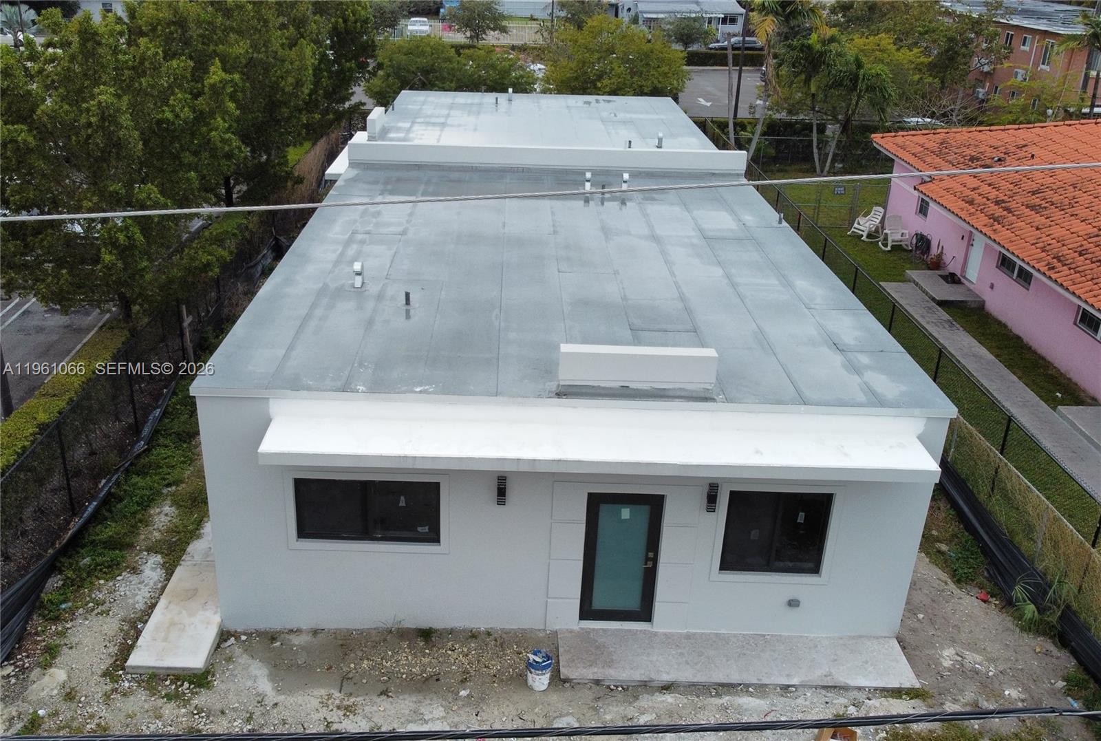 An aerial view shows the exterior of a white, flat-roofed building with a front entrance — 2474 W 4th Ct, Hialeah FL 33010, HIALEAH, FL