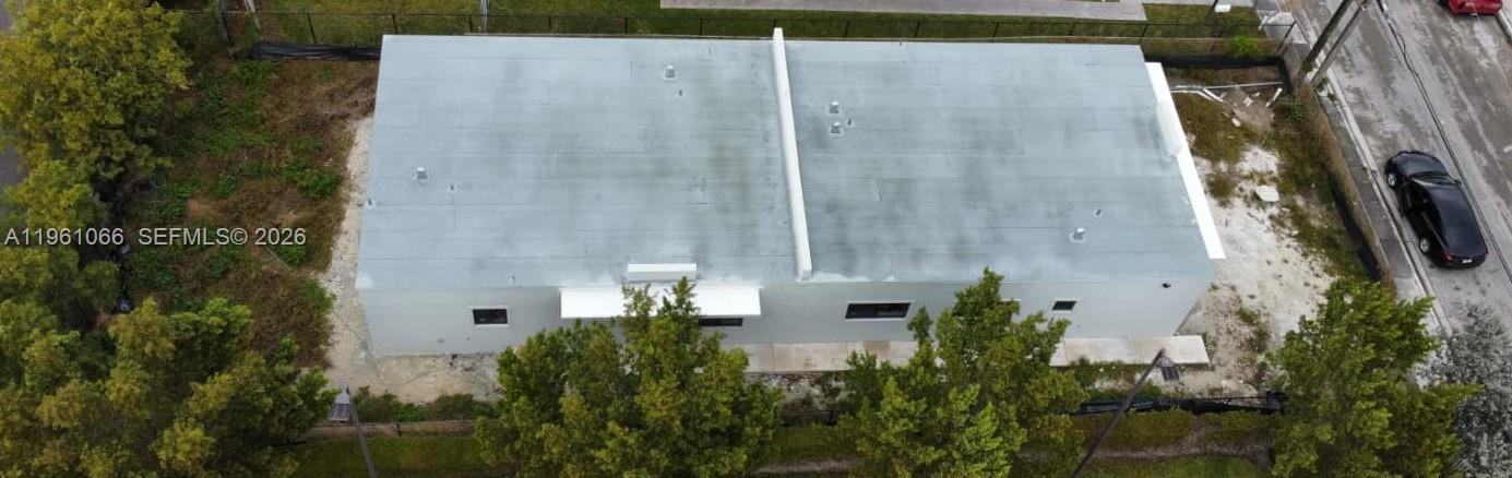 An aerial view shows a rectangular, flat-roofed building surrounded by trees and a parking area — 2474 W 4th Ct, Hialeah FL 33010, HIALEAH, FL