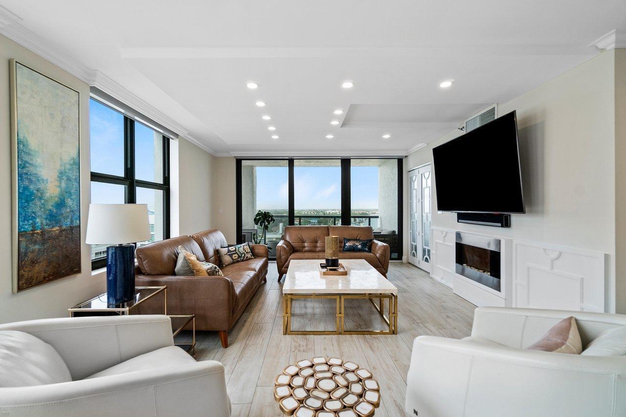 A modern living room features two leather sofas, white armchairs, a marble coffee table, and windows — 3115 S Ocean Boulevard # 1001, Highland Beach FL 33487, HIGHLAND BEACH, FL