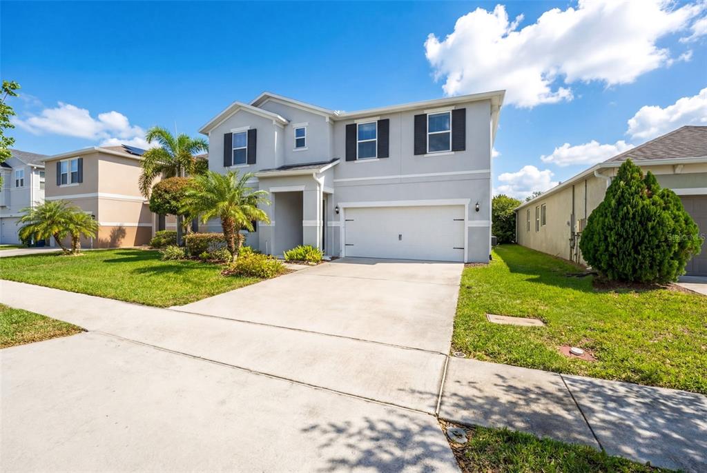 A two-story suburban house with a gray exterior, white garage door, and a concrete driveway — 14505 WARD ROAD, ORLANDO, FL