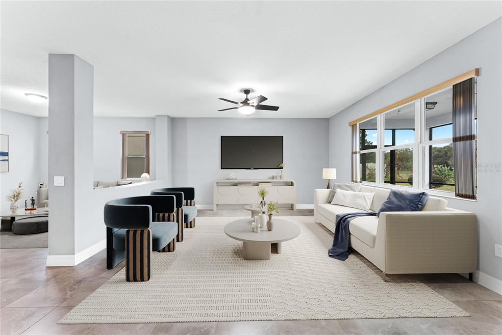 A bright living room features a white sofa, two modern chairs, and a television console — 14505 WARD ROAD, ORLANDO, FL