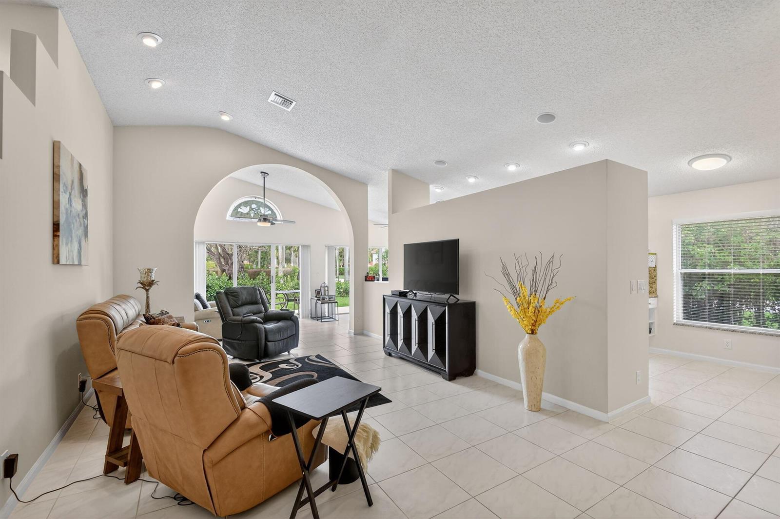A living room features tan leather recliners, a black media console, and light tile flooring — 9718 Harbour Lake Circle, Boynton Beach FL 33437, BOYNTON BEACH, FL