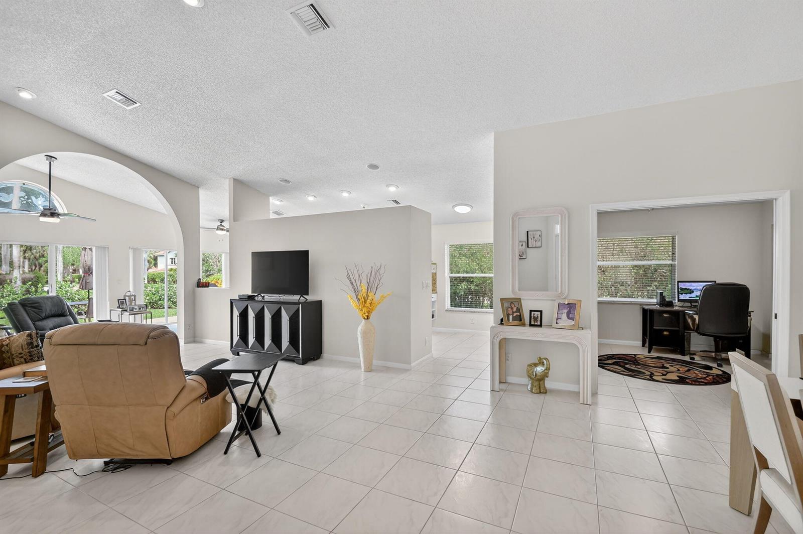 A spacious living room with tile floors, a central partition wall, and an adjacent office — 9718 Harbour Lake Circle, Boynton Beach FL 33437, BOYNTON BEACH, FL
