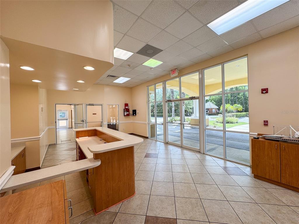 A commercial lobby features a reception desk, tile flooring, and large windows overlooking a parking lot — 690 LAKE FOREST BOULEVARD UNIT Suite 1, SANFORD, FL