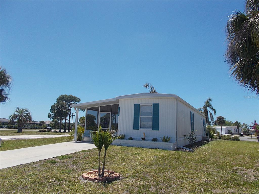 A single-story mobile home with a screened-in porch and a concrete driveway — 7622 SILAGE CIRCLE, PORT CHARLOTTE, FL