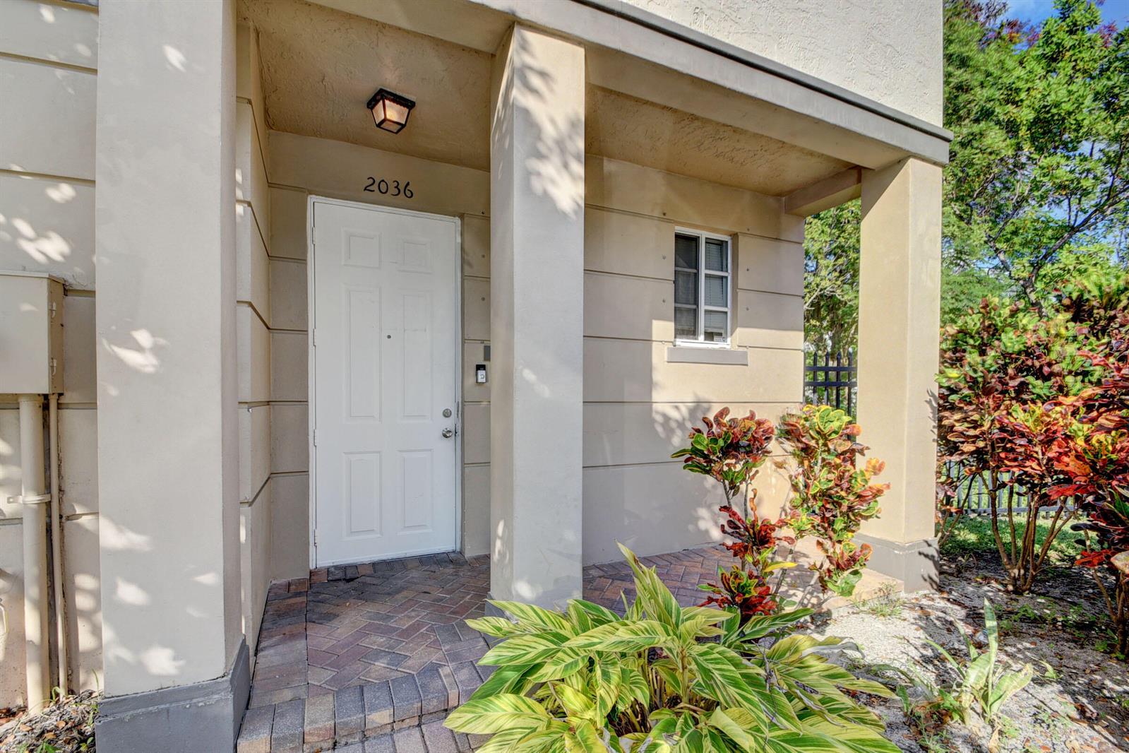 The exterior entrance features a white door, a brick walkway, and a small window — 2036 Marsh Harbor Drive, West Palm Beach FL 33404, WEST PALM BEACH, FL