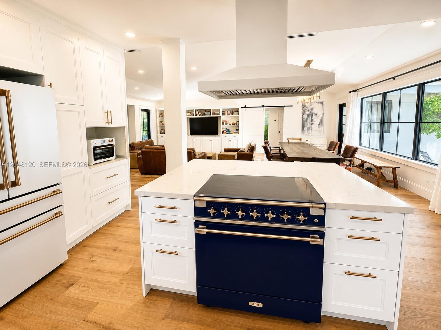 A kitchen features a blue AGA range, white cabinetry, and an island with quartz countertops — 4455 N Bay Rd, Miami Beach FL 33140, MIAMI BEACH, FL