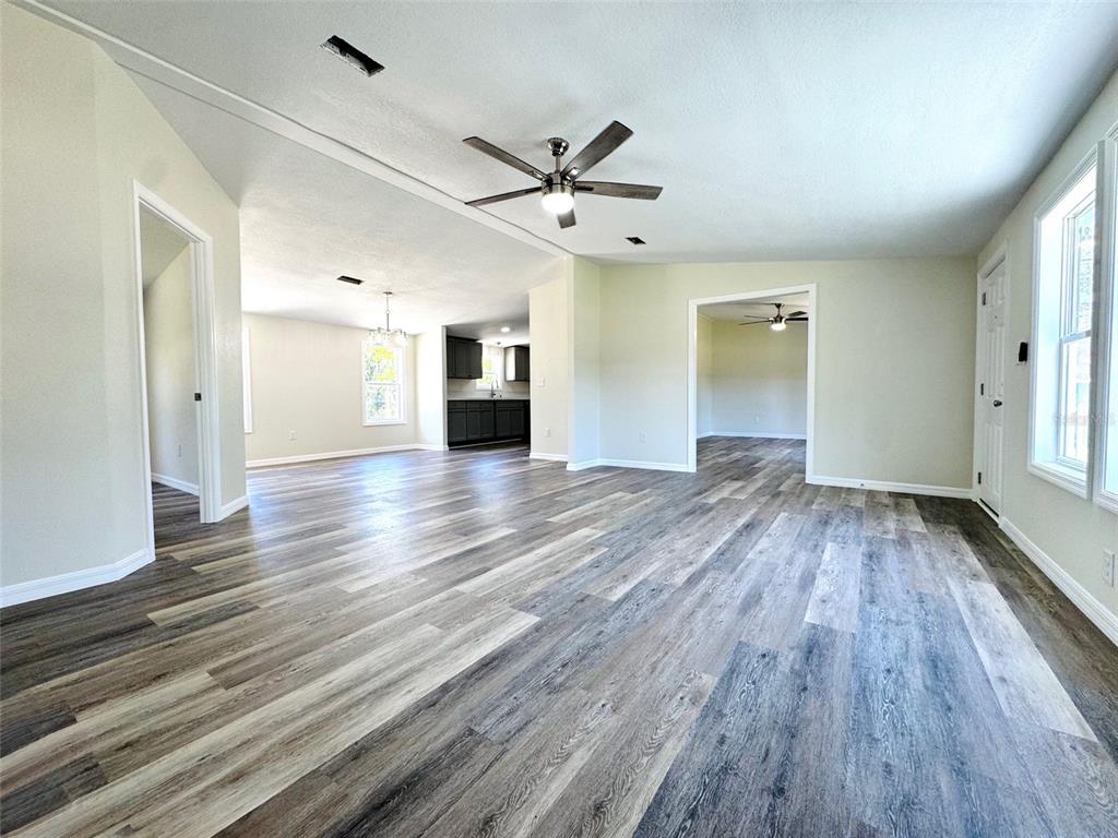 A living area with light-colored walls, wood-look flooring, and a ceiling fan — 4220 OLD DIXIE HIGHWAY, AUBURNDALE, FL