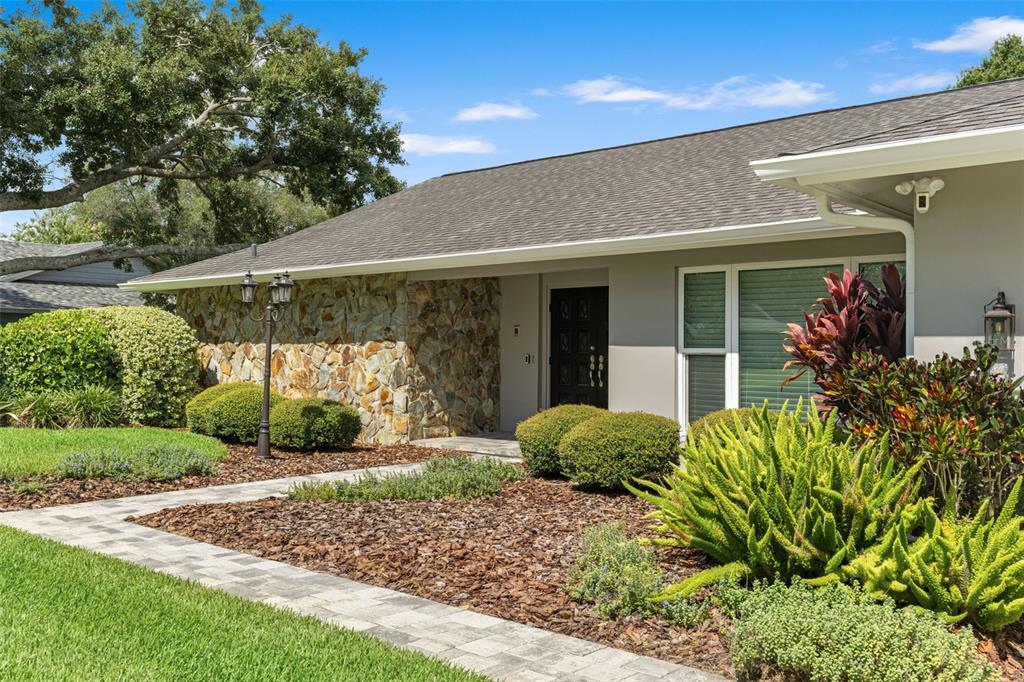 A single-story house features a stone facade, a paved walkway, and landscaped front yard — 13916 MIDDLE PARK DRIVE, TAMPA, FL