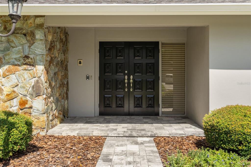 A stone-accented exterior features a double front door and a paved walkway — 13916 MIDDLE PARK DRIVE, TAMPA, FL