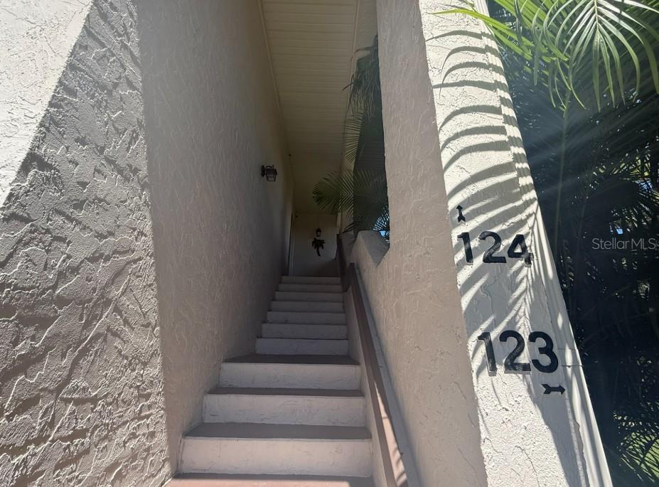 An exterior staircase leads up to the entrance of units 123 and 124 — 3500 EL CONQUISTADOR PARKWAY UNIT 124, BRADENTON, FL