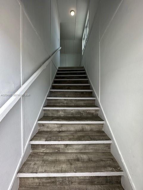 A straight staircase with wood-look treads and white walls leads to an upper landing — 274 E 9th St # 4, Hialeah FL 33010, HIALEAH, FL