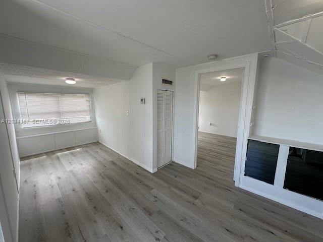 A room with light wood-look flooring, a window with blinds, and an open doorway — 274 E 9th St # 4, Hialeah FL 33010, HIALEAH, FL