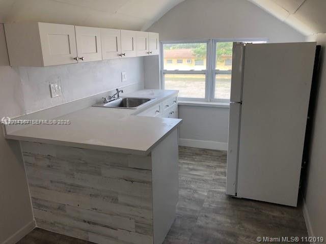A kitchen features white cabinets, a sink, a white refrigerator, and wood-look flooring — 274 E 9th St # 4, Hialeah FL 33010, HIALEAH, FL