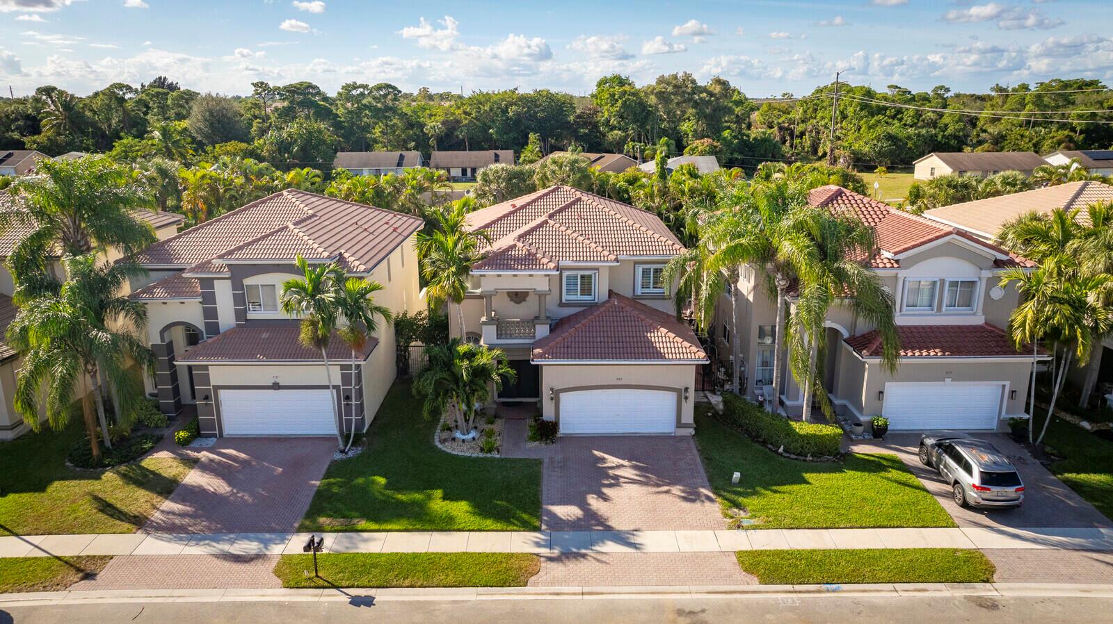 An aerial view shows three two-story suburban houses with tiled roofs and attached garages — 7167 Ivy Crossing Lane, Boynton Beach FL 33436, BOYNTON BEACH, FL