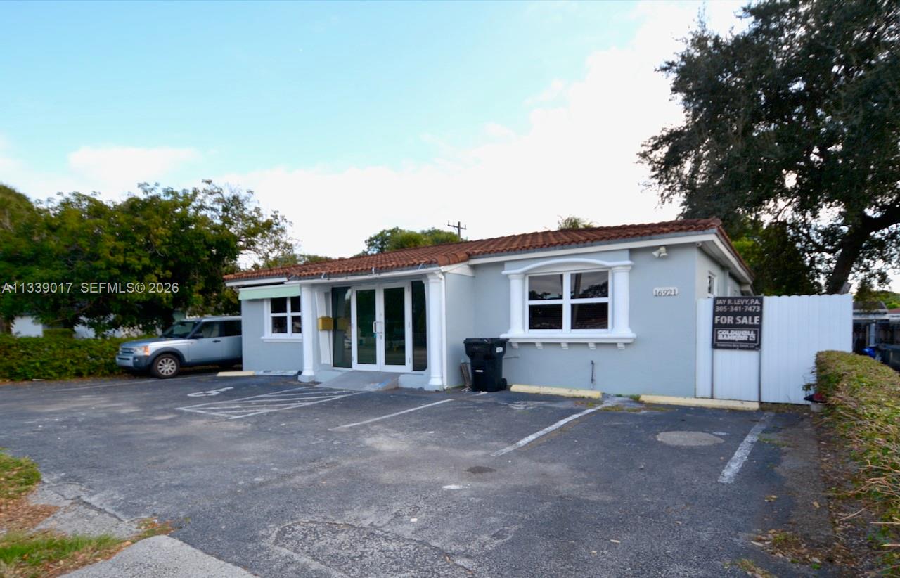 A single-story commercial building with a gray exterior, a tiled roof, and a paved parking lot — 16921 NE 6th Ave, North Miami Beach FL 33162, NORTH MIAMI BEACH, FL