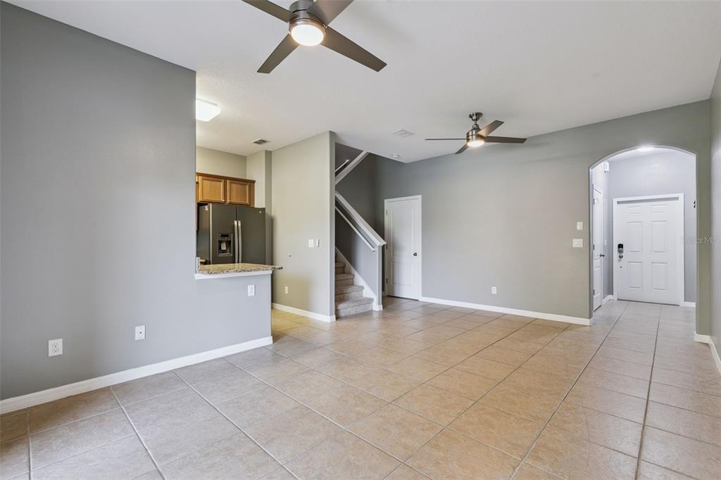 An open-concept living area features tile flooring, a kitchen pass-through, and a staircase — 1250 TWIN TREES LANE, SANFORD, FL