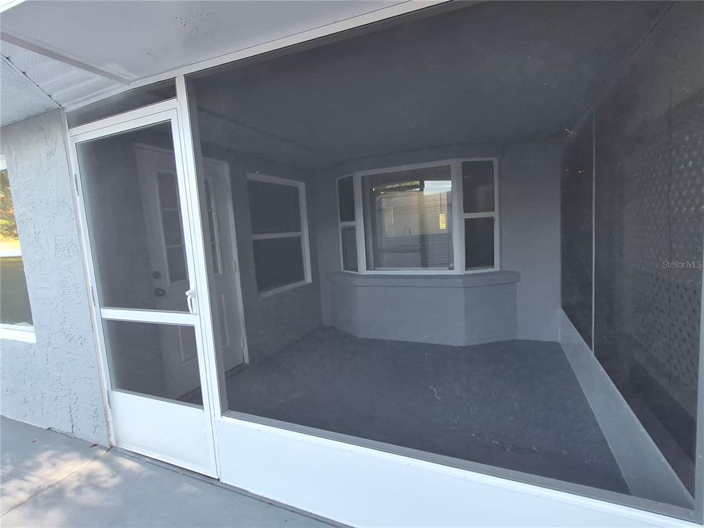 A screened-in porch with gray walls, a concrete floor, and a bay window — 1213 W SORRENTO DRIVE, CITRUS SPRINGS, FL